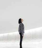 Woman looking up, isolated in a bland white area