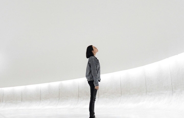 Woman looking up, isolated in a bland white area