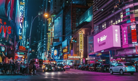 Times Square lit up at night, showing many brands off